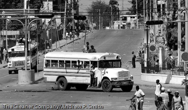 Two buses filled with armed men drive through the streets of Port-au-Prince on February 29, 2004, the day that Jean Bertrand Aristide was deposed as Haiti's president.