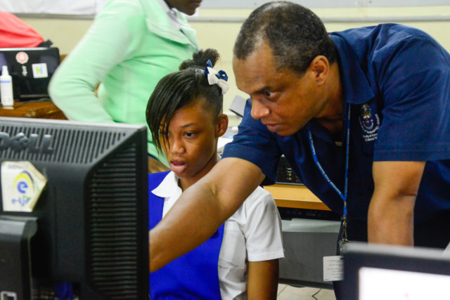 Workshop facilitator Andrew Smith of UTech Jamaica assists a student of Buff Bay High School during a heritage education workshop organised in Buff Bay, Portland on November 1 2016.